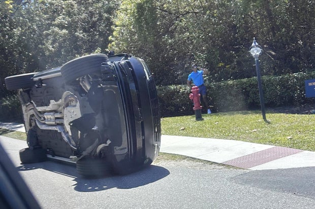 Tiger Woods stands by his overturned vehicle after a crash in Florida