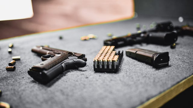 Firearms, Magazines And Cartridges On Shooting Range Booth Table 