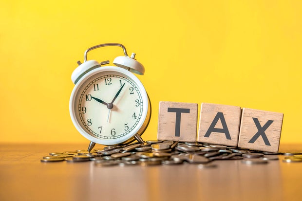 Tax text written on wooden block with stacked coins