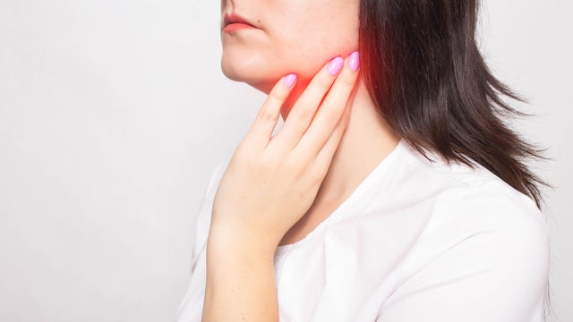 The girl clings to the inflamed salivary gland in which pain. Concept of salivary gland disease, mumps, cancer, copy space 