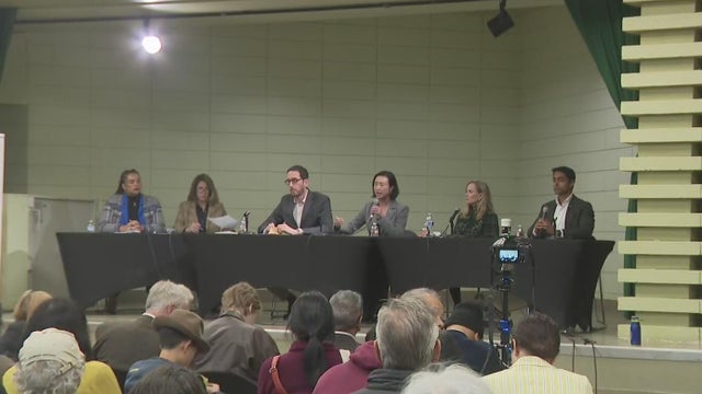 several people sitting at a table during a debate 