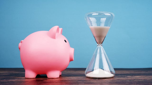 Piggy Bank and Hourglass on Blue Background 