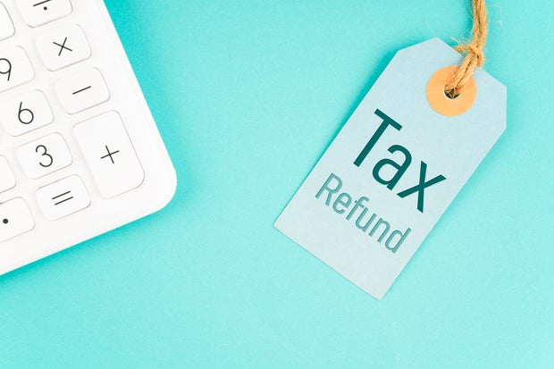 Tax refund on product price tags with calculator on blue background. 