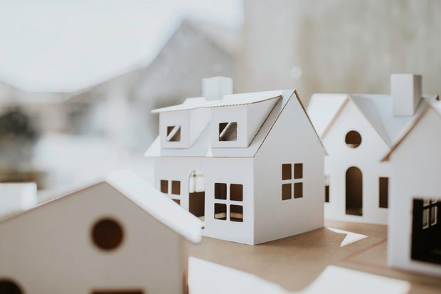 Simple image of a village of white cardboard houses in various shapes and sizes 