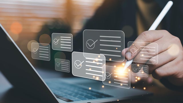 Businessman using digital checklist interface on laptop with stylus pen, task management, online survey form, quality control, project planning, compliance audit, productivity and workflow automation. 