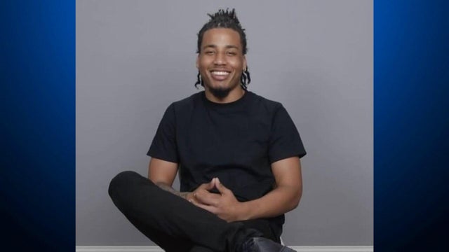 A man sits in a chair for a photograph 