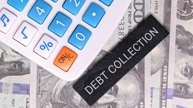 Calculator and "Debt Collection" label placed on US dollar bills, representing debt recovery, finance, and payment. 