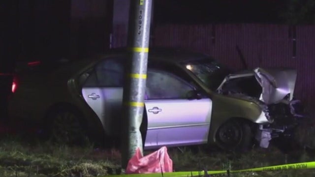 A vehicle with front-end damage next to a dented utility pole 
