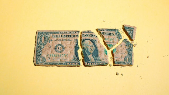 Dollar Bill Breaking Apart into Pieces on Yellow Background 