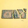 Dollar Bill Breaking Apart into Pieces on Yellow Background 