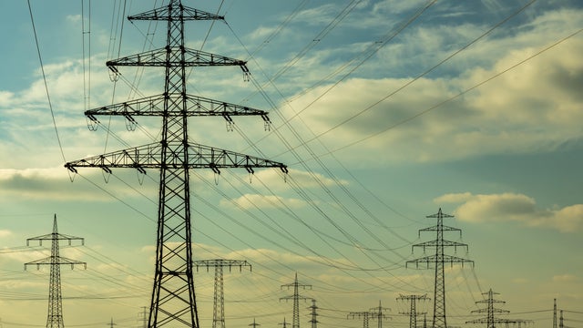 Many large electricity pylons at sunset 