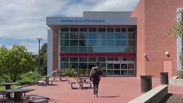 A person walking toward a building at Contra Costa College 