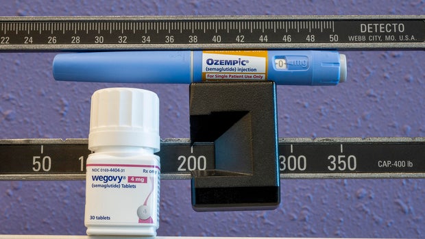 Still life of the new Wegovy 4mg semaglutide tablets with Ozempic injectable pen and weight scale 