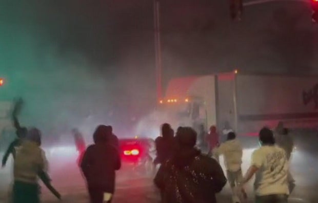 People running toward the scene of a crash at a sideshow 