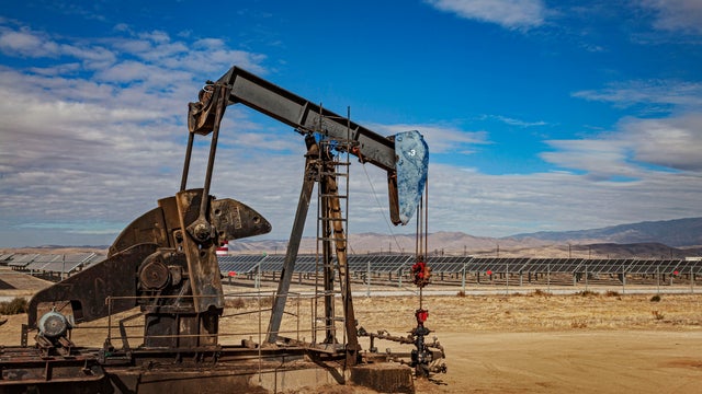 Lone pumpjack located in the middle of large solar array outside of Bakersfield 