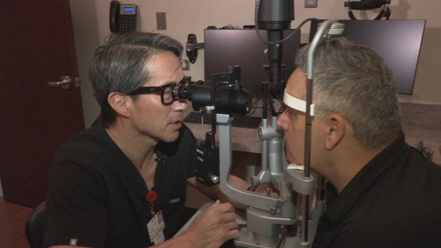Dr. Ho examines a patient's eyes 