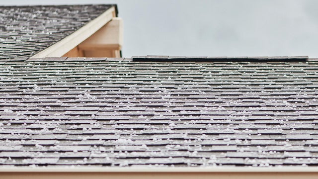Roof shingles with large hailstones after hail storm 