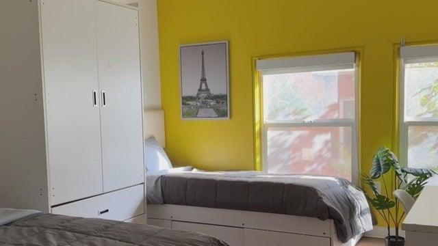 a room with two beds and a dresser 