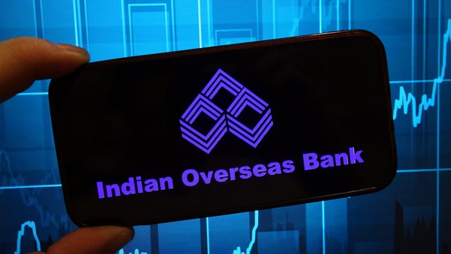 In this photo illustration, the Indian Overseas Bank company 