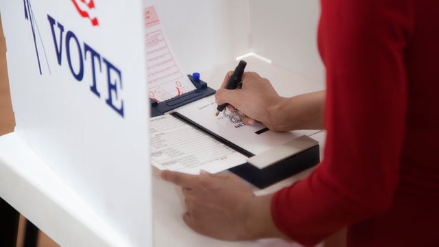 Asian voter voting in polling place 