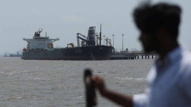 A man looks at India-flagged tanker Desh Garima, as it unloads crude oil at an offloading terminal after transiting the Strait of Hormuz, amid supply disruptions linked to the U.S.-Israeli conflict with Iran, in Mumbai 
