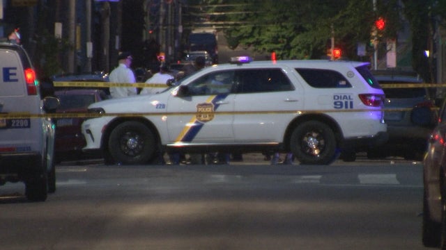 Police cars, officers and crime scene tape at the scene of a shooting in Philadelphia 
