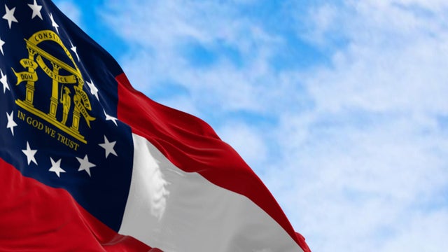 Close-up of Georgia state flag waving in the wind on a clear day 