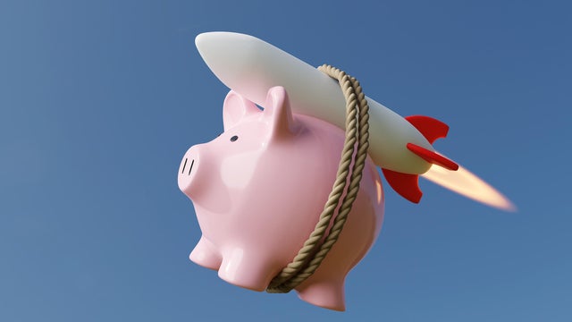 Pink piggy bank carried by a rocket in clear blue sky. Illustration of the concept of skyrocketing prices of stocks and other investment 