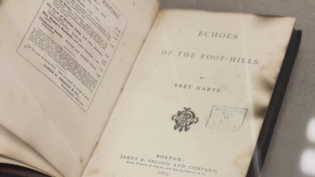 a book opened to the title page which has been slightly scorched on the edges 