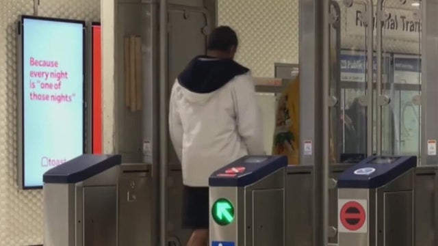 two people going through a transit gate 