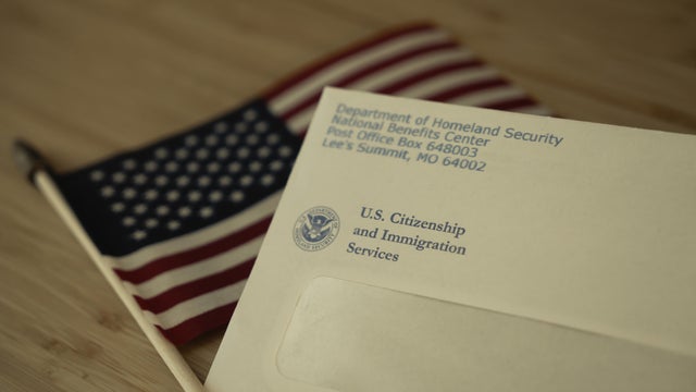 USCIS envelope on blurred Flag of USA background 