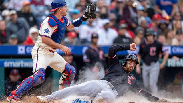 Cleveland's Daniel Schneemann slides into home on a single hit by teammate Steven Kwan as Philadelphia Phillies catcher J.T. Realmuto waits for the ball 