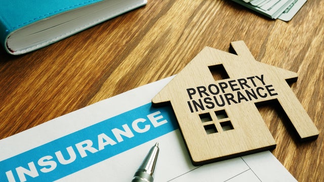 Property insurance stamp on a model wooden home. 