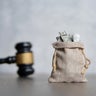 Closeup image bag of money and judge gavel. 
