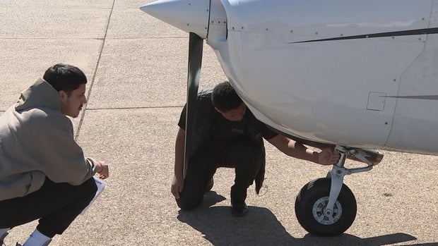 Jonathan Suarez (right) working on a plane with a fellow student