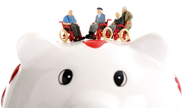 Figurine on wheelchairs on piggy bank 