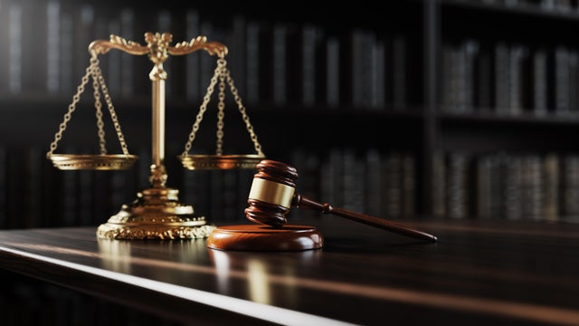 Legal concept: Scales of justice and and the judge's gavel hammer as a symbol of law and order on the background of books 