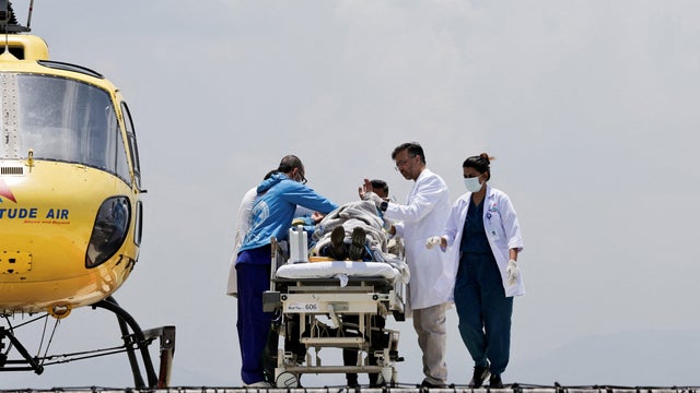 Paramedics work to transport Dawa Sherpa, who was missing for several days in the Everest region, from the helipad at HAMS Hospital in Kathmandu 