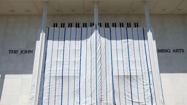 Workers stand on scaffolding outside the Kennedy Center on June 12, 2026, ahead of a deadline to remove President Trump's name from the building. 