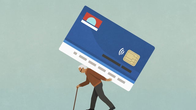 Senior man with cane walking with large credit card burden on back 