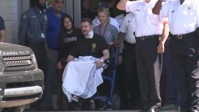 A police officer in a wheelchair is taken out of the hospital 
