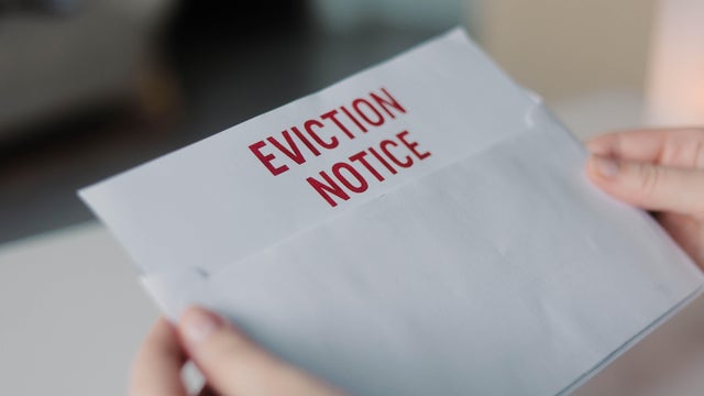 Person pulling an eviction notice letter from a white envelope. Concept of housing issues, rental problems and eviction process 