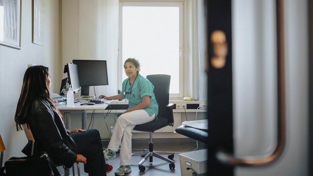 Female physician discussing with young woman in clinic 