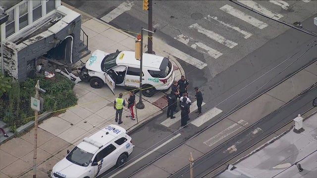 A small SUV taxi is parked outside a house after crashing into it 