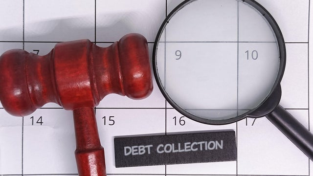 Debt collection concept with gavel and magnifying glass 