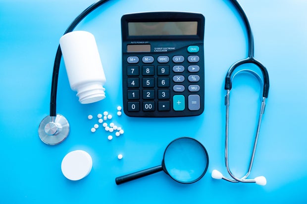 pills and medicines under a magnifying glass next to a medical stethoscope. The concept of health and responsible use of medicines, vitamins and various supplements 