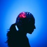 Profile headshot silhouette in vibrant abstract light, suggesting innovation and contemplation, topics of brain and cognitive functions 