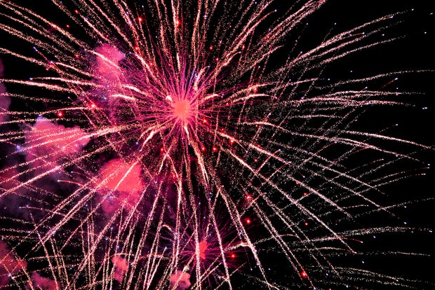 Red fireworks exploding against dark night sky 