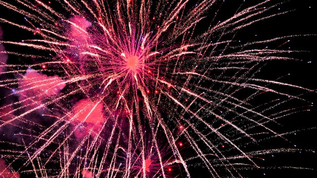 Red fireworks exploding against dark night sky 