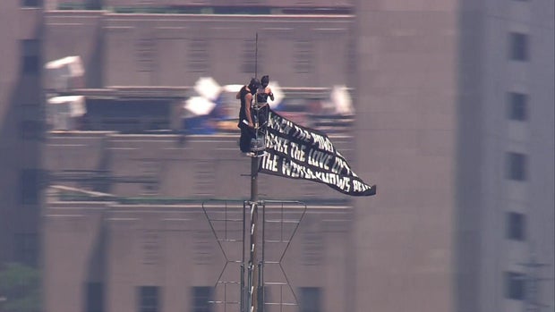2 people climb to top of NYC's Empire State Building, fly banner